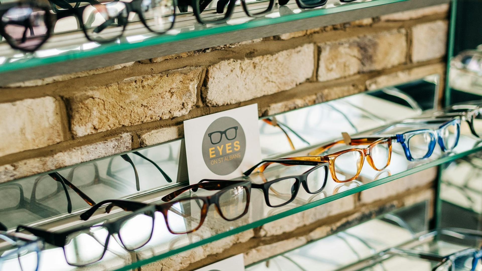 Présentoir rempli de lunettes dans un magasin d'optique, illustrant la vitrine d'un opticien indépendant