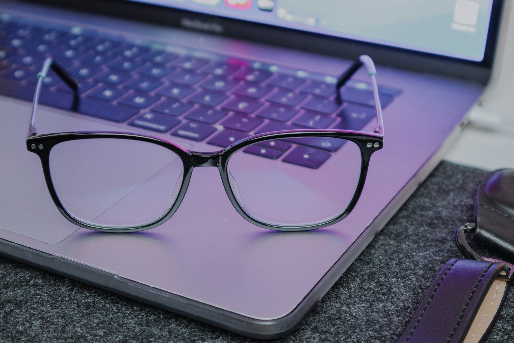 Lunettes posées sur un ordinateur portable, le lien entre lunettes connectées et lumière bleue des écrans
