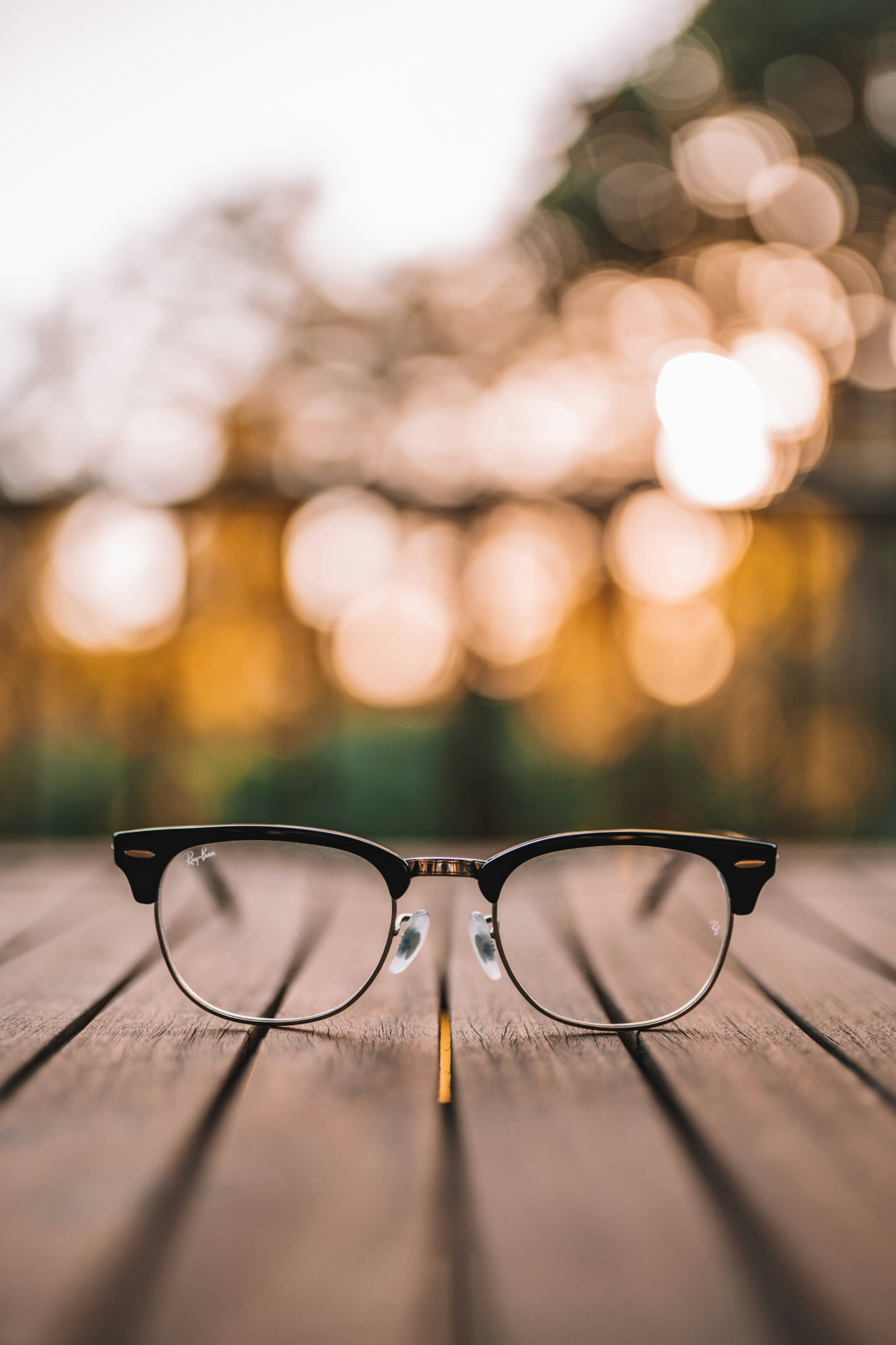 Lunettes posées sur une table en bois, évoquant le besoin de réparation