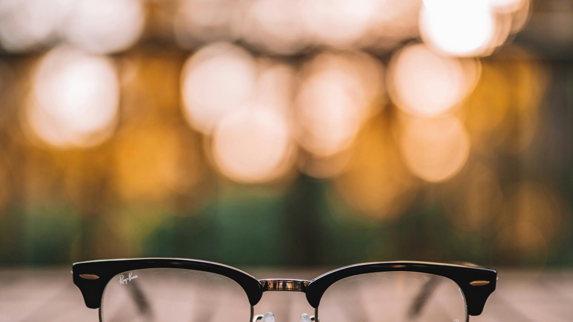 Lunettes posées sur une table en bois, évoquant le besoin de réparation