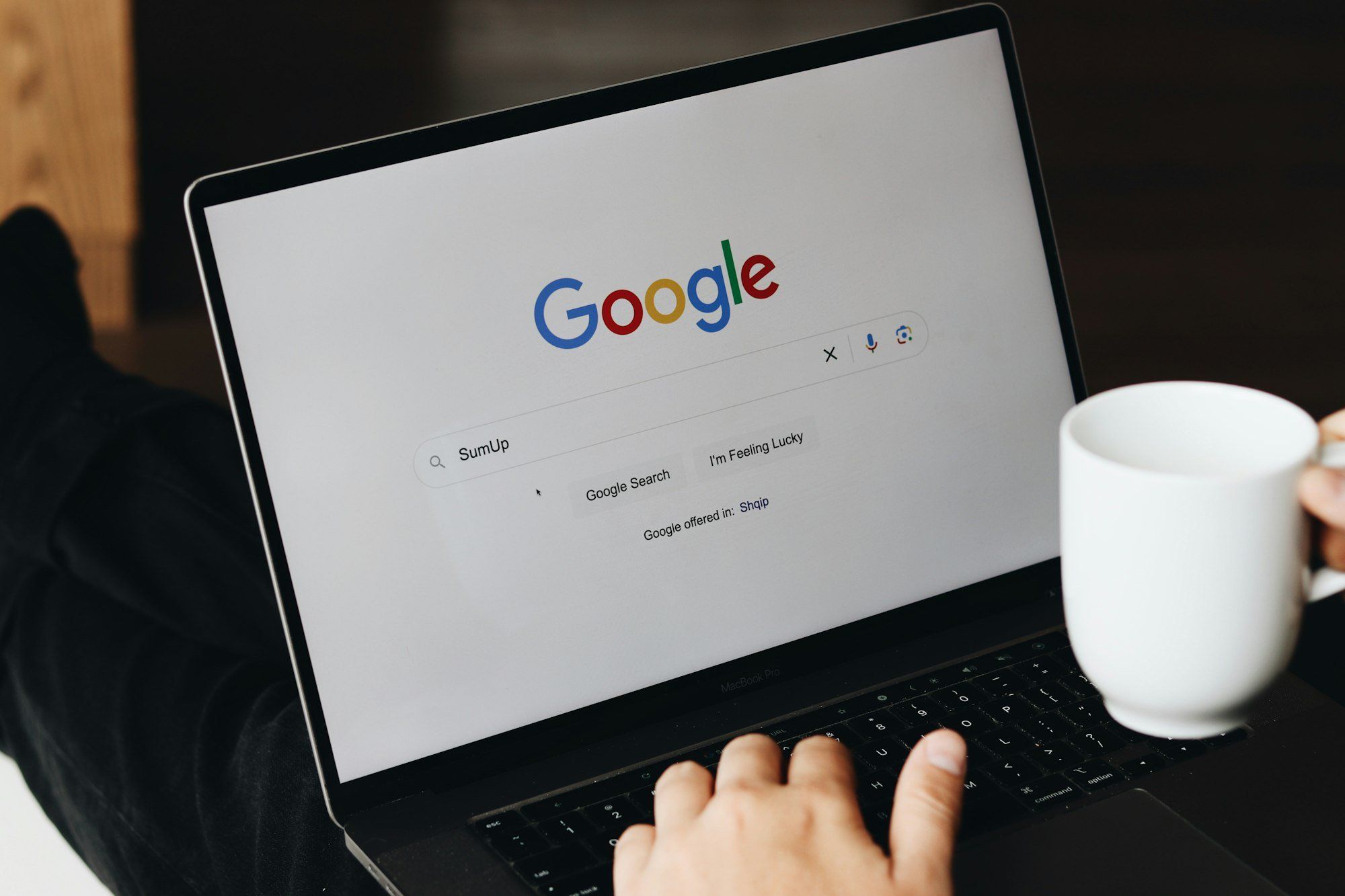 Client assis devant un ordinateur portable, consultant un avis en ligne