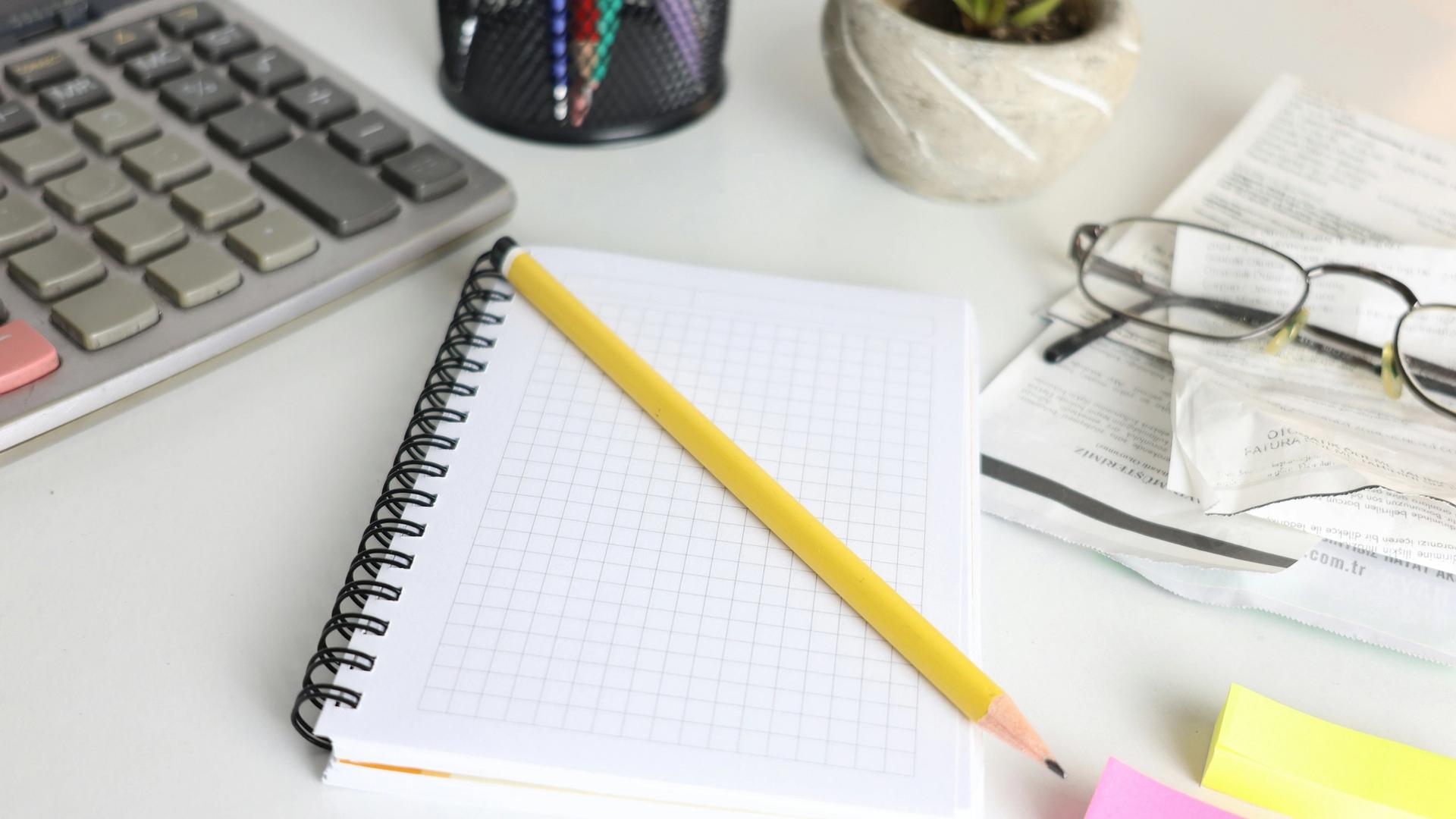 Bureau avec calculatrice et lunettes, budget et financement d'un opticien indépendant