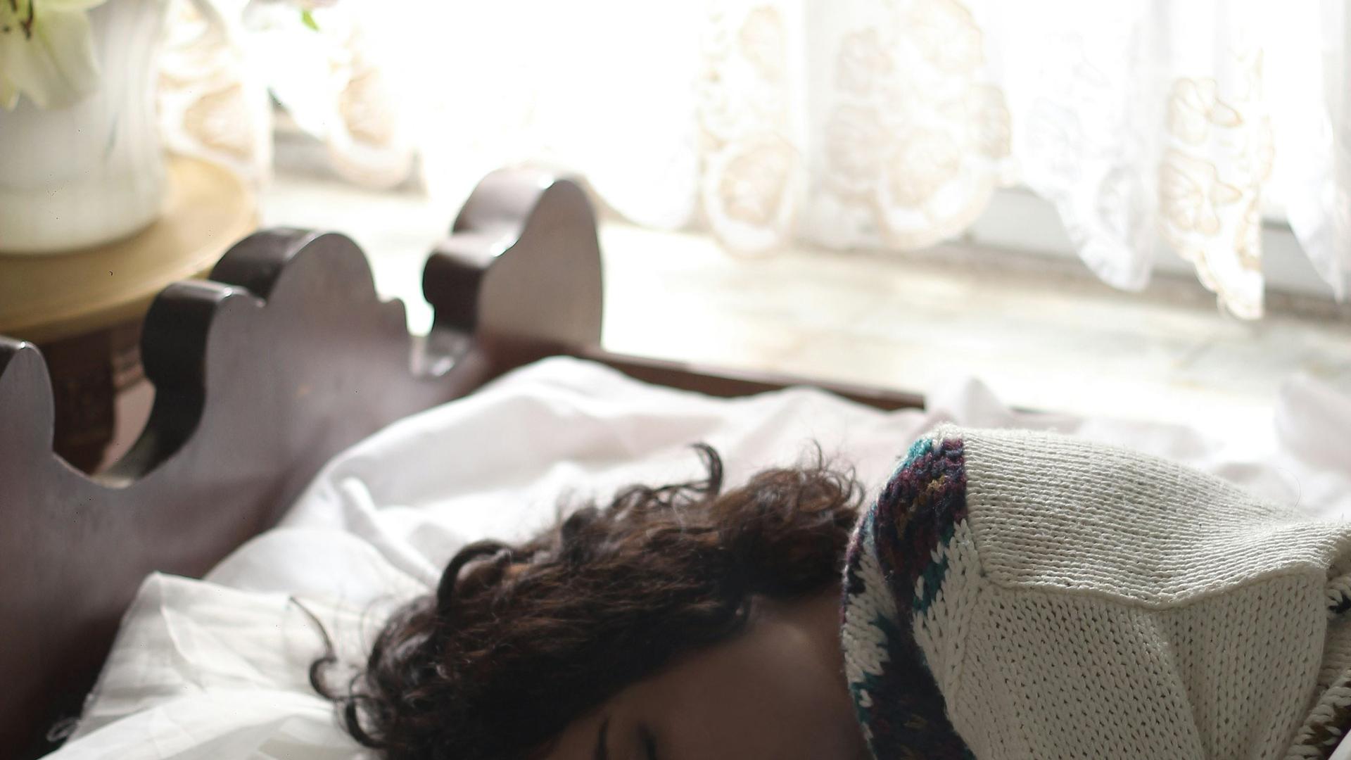 Femme endormie dans son lit, le manque de sommeil est la cause la plus fréquente d'un œil qui saute