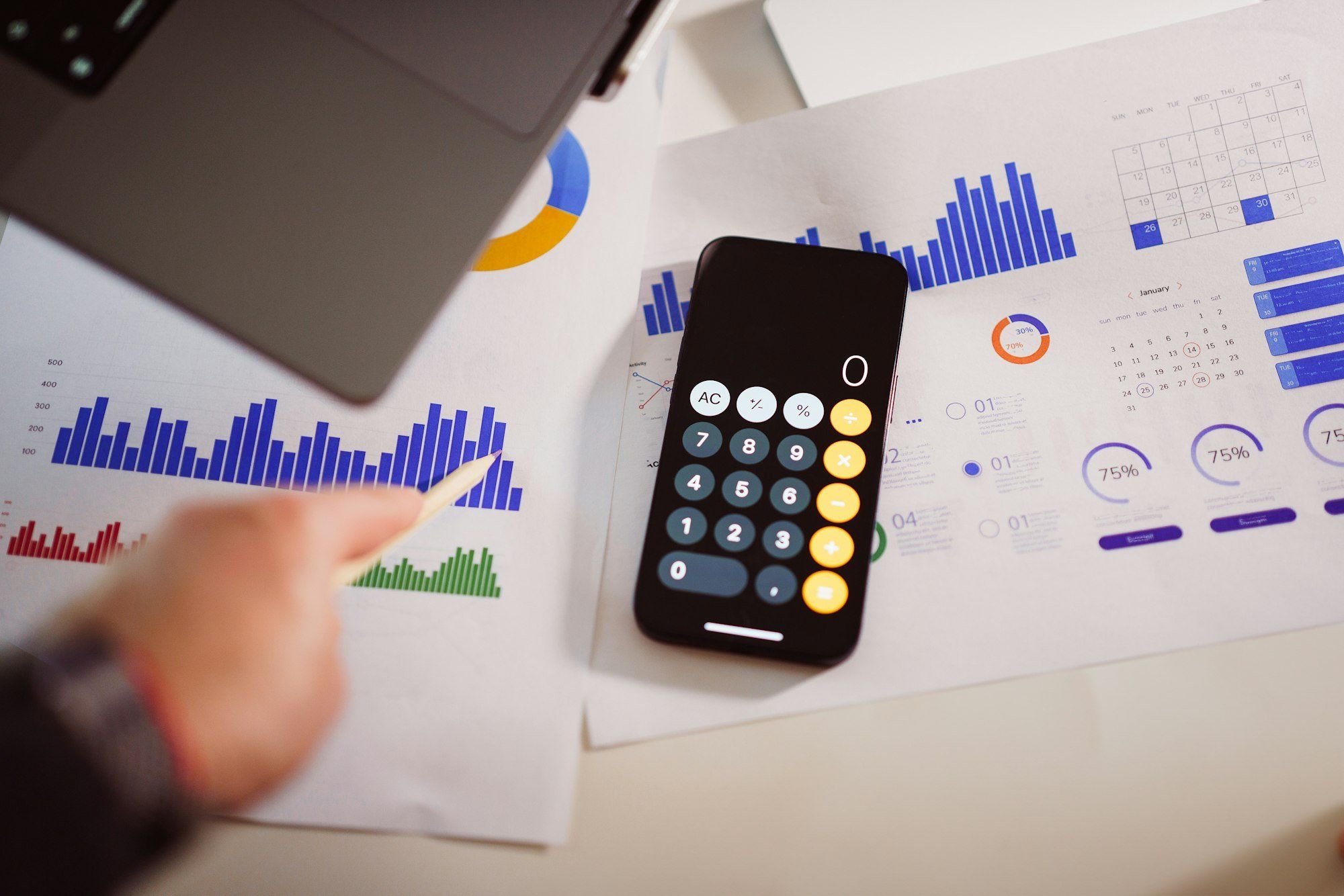 Calculatrice posée sur des documents financiers et graphiques, pour le calcul du budget publicitaire