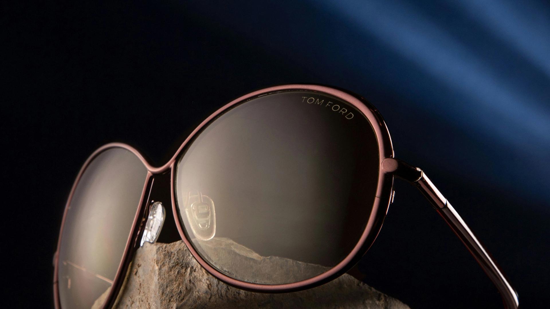 Lunettes de soleil design posées sur une pierre, évoquant l'authenticité