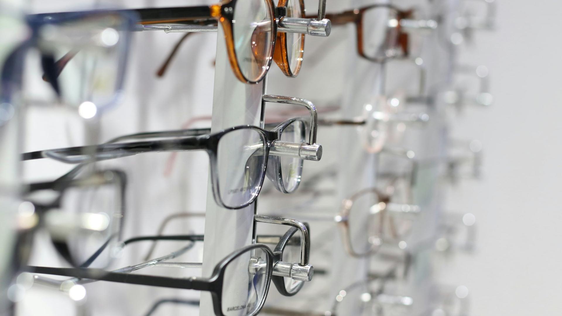 Lunettes à monture argentée posées sur une surface en verre, dans une boutique d'optique, illustrant le recrutement d'un apprenti opticien.