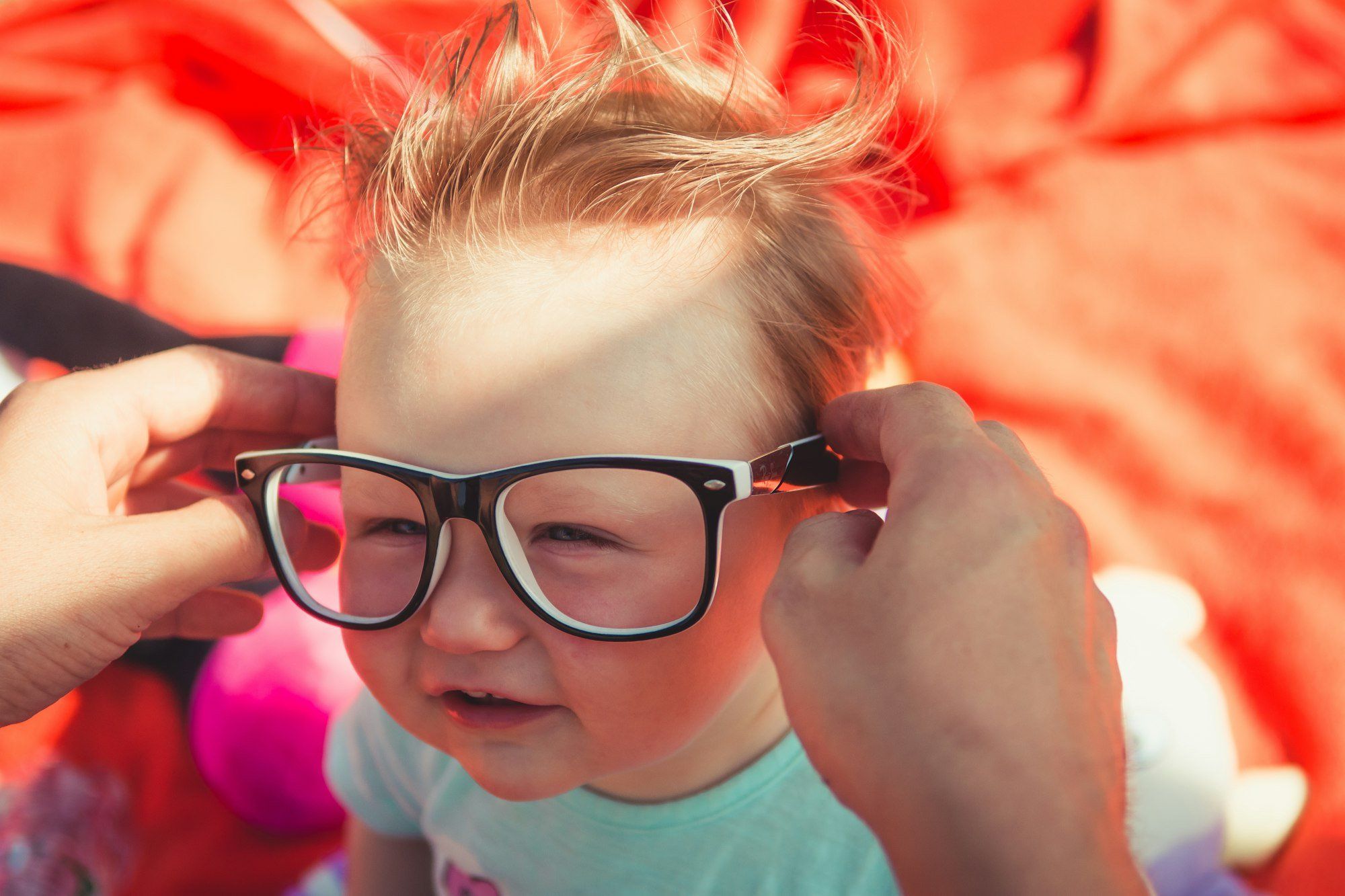 Jeune enfant portant des lunettes à monture noire, les symptômes de l'amblyopie étant souvent repérés lors de l'adaptation d'une première correction