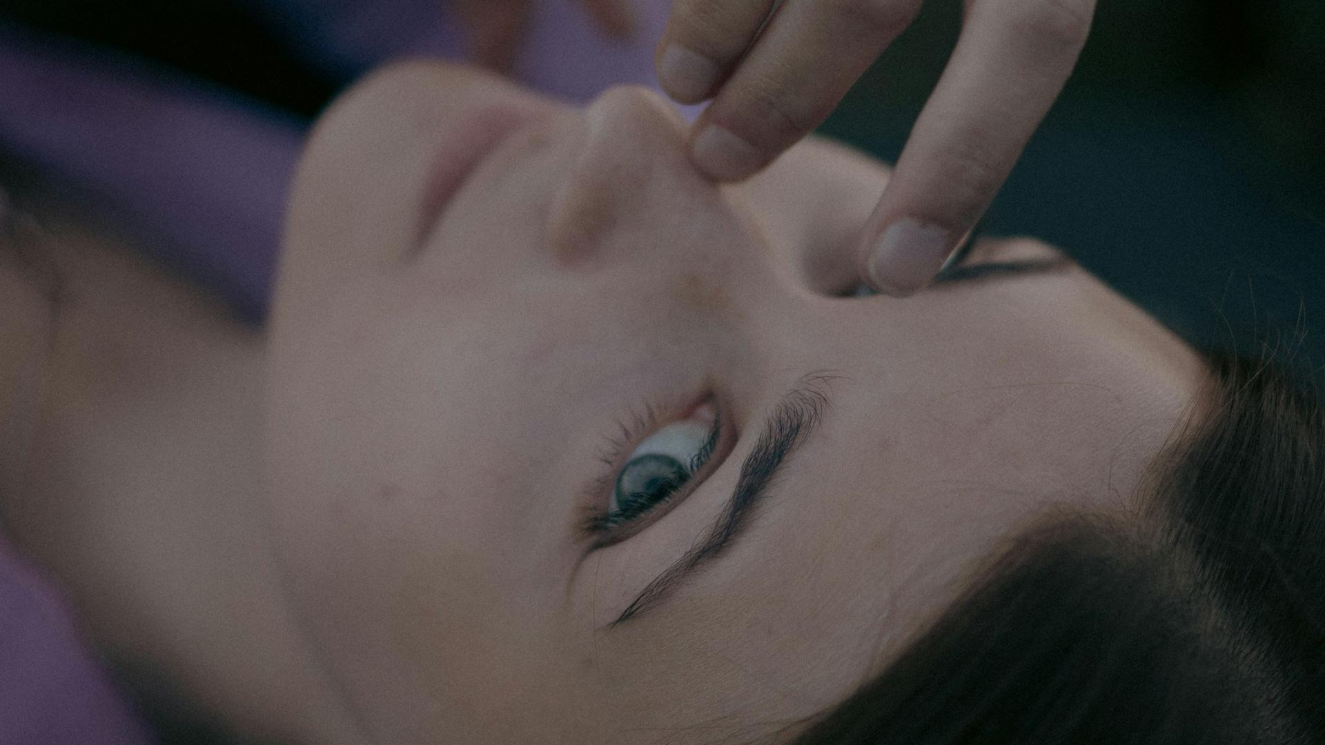Femme détendue recevant un massage de la tête, la gestion du stress aide à calmer les spasmes de la paupière