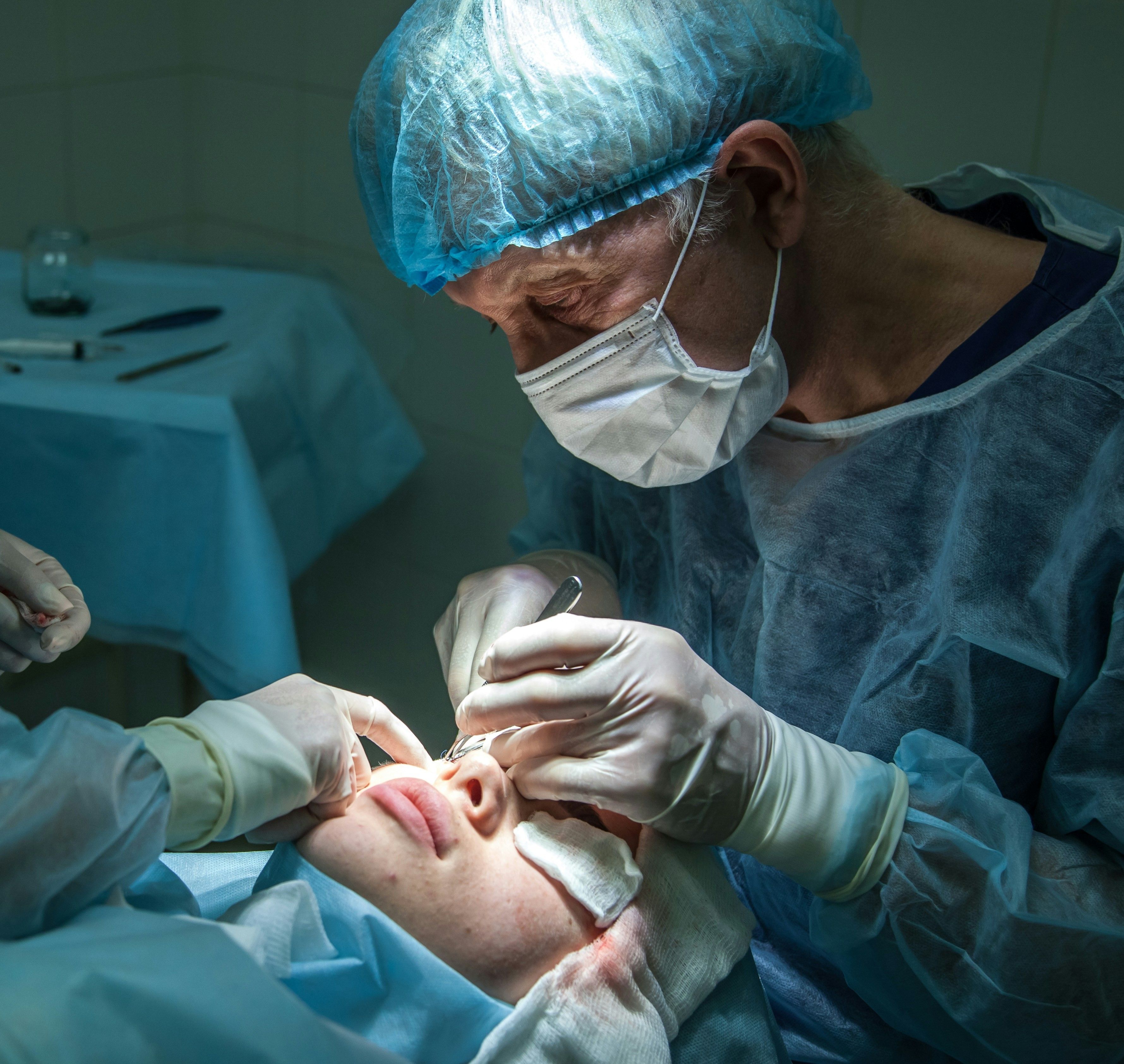 Chirurgien réalisant une intervention au laser sur un patient au bloc opératoire