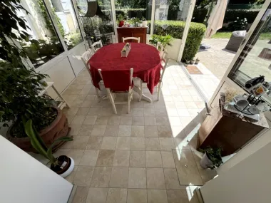 Pose de carrelage effet pierre naturelle dans une véranda — Sol intérieur en Sarthe