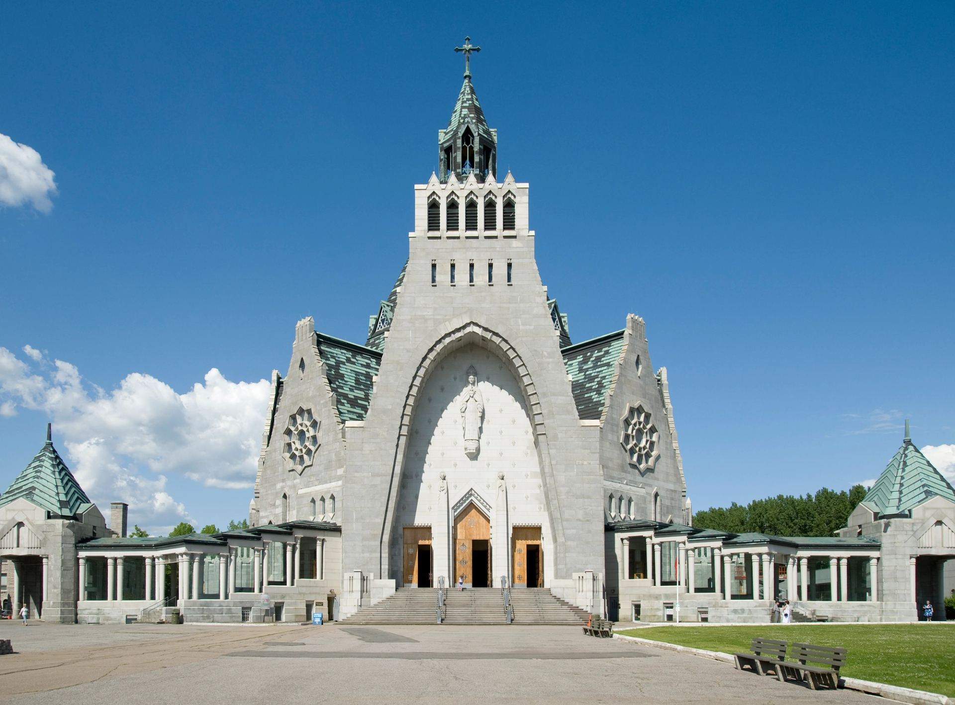 Vue frontale de la façade en pierre du sanctuaire Notre-Dame-du-Cap sous un ciel bleu