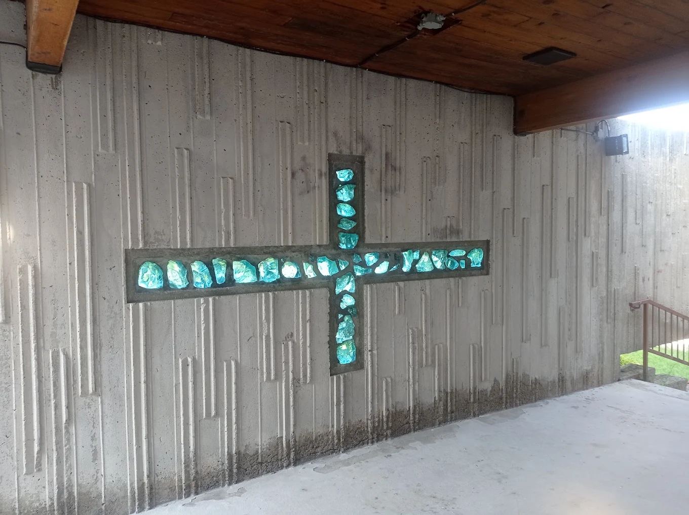 Croix composée de verre coloré intégrée à une paroi de béton