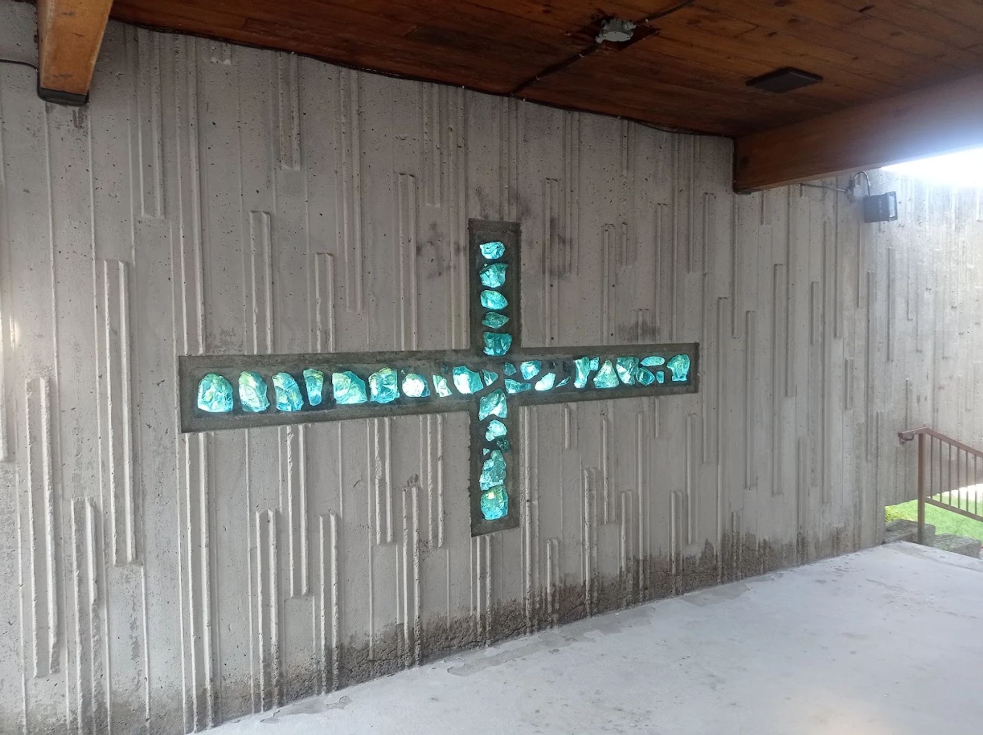 Croix composée de verre coloré intégrée à une paroi de béton
