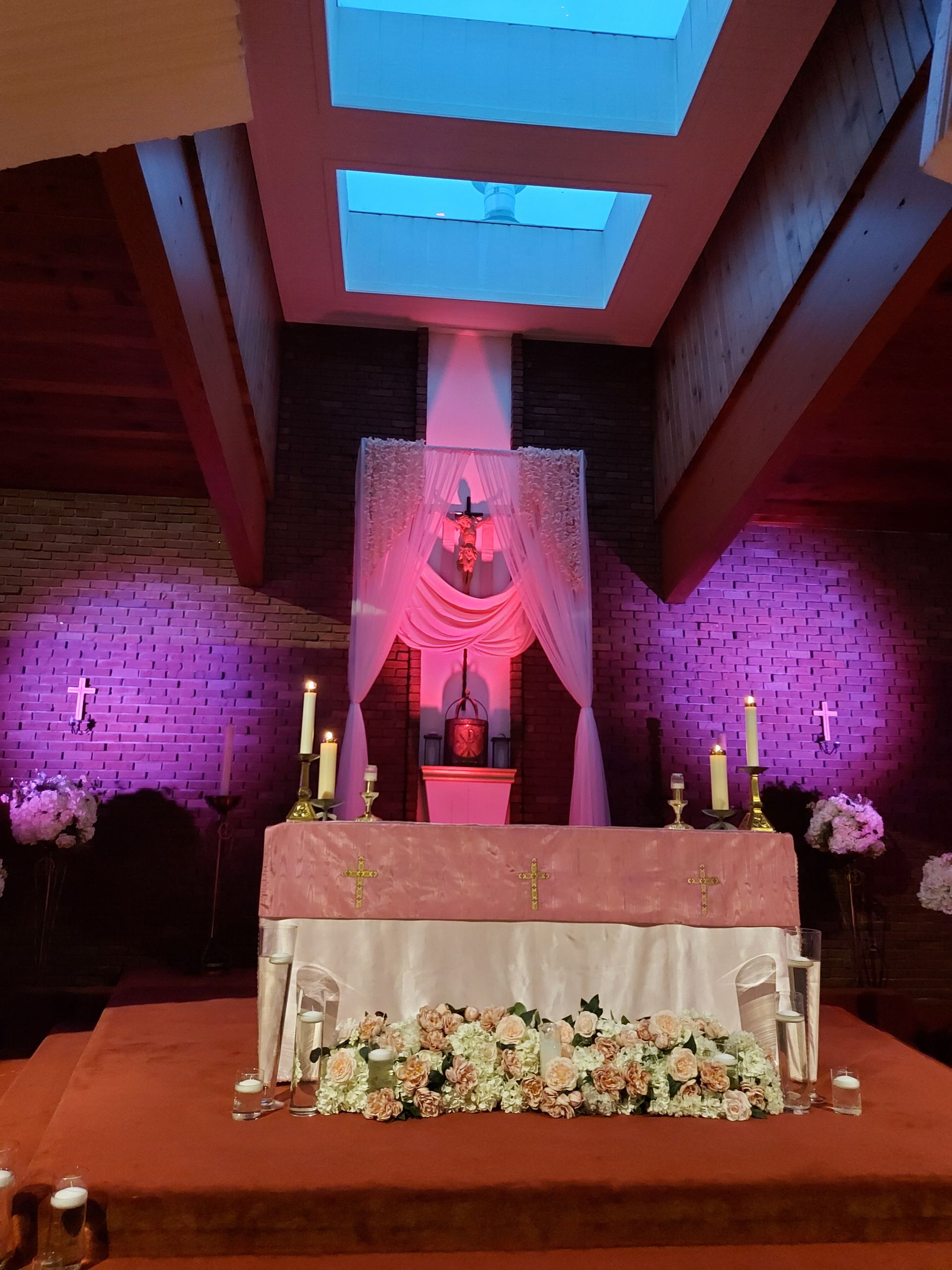 Autel fleuri sous un éclairage rose dans l’église