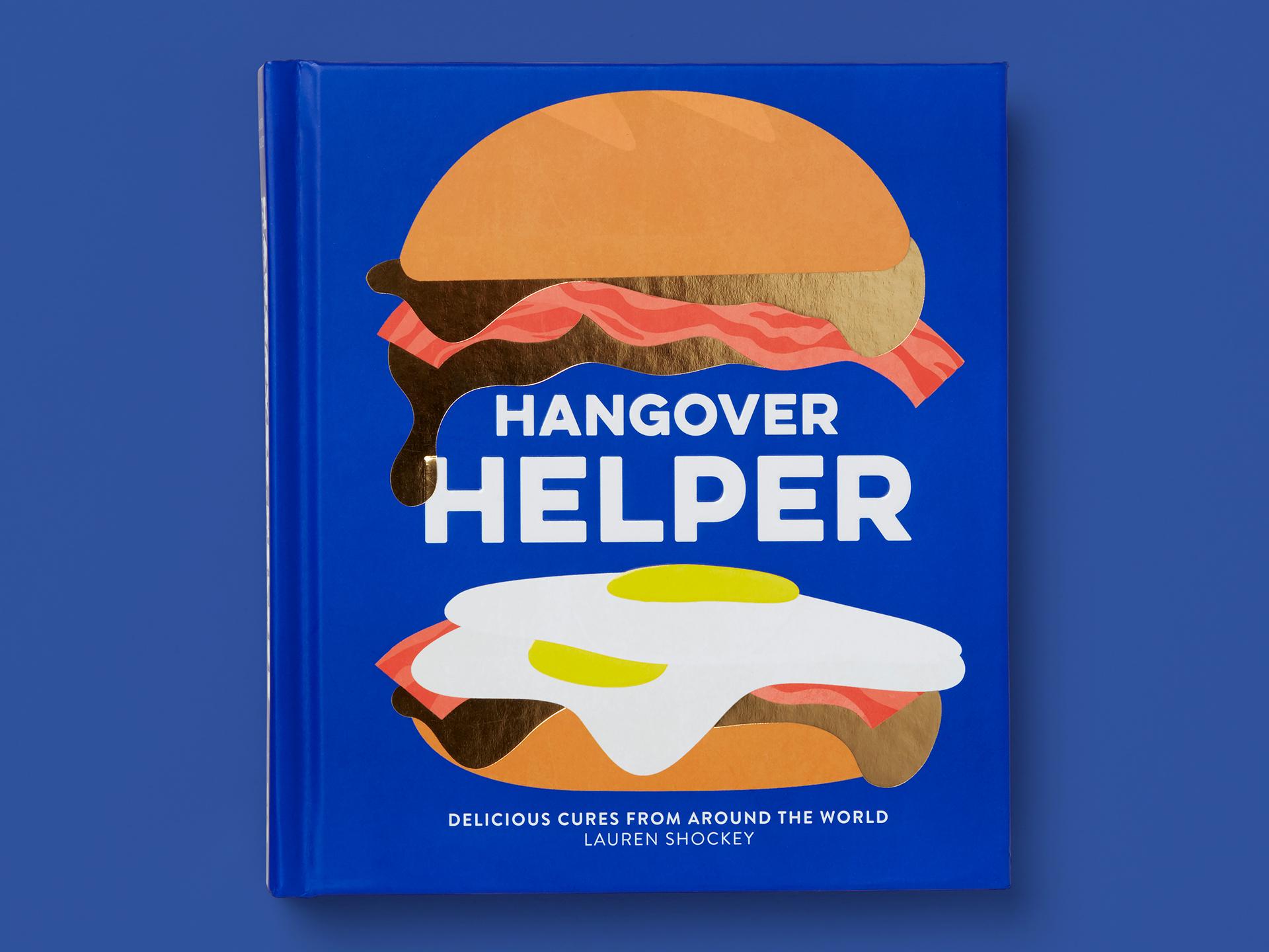 Book titled "Hangover Helper" on a deep blue background, featuring bold white typography and a playful illustrated burger with bacon and a fried egg. Subtitle reads "Delicious cures from around the world," with the author's name, Lauren Shockey, at the bottom.