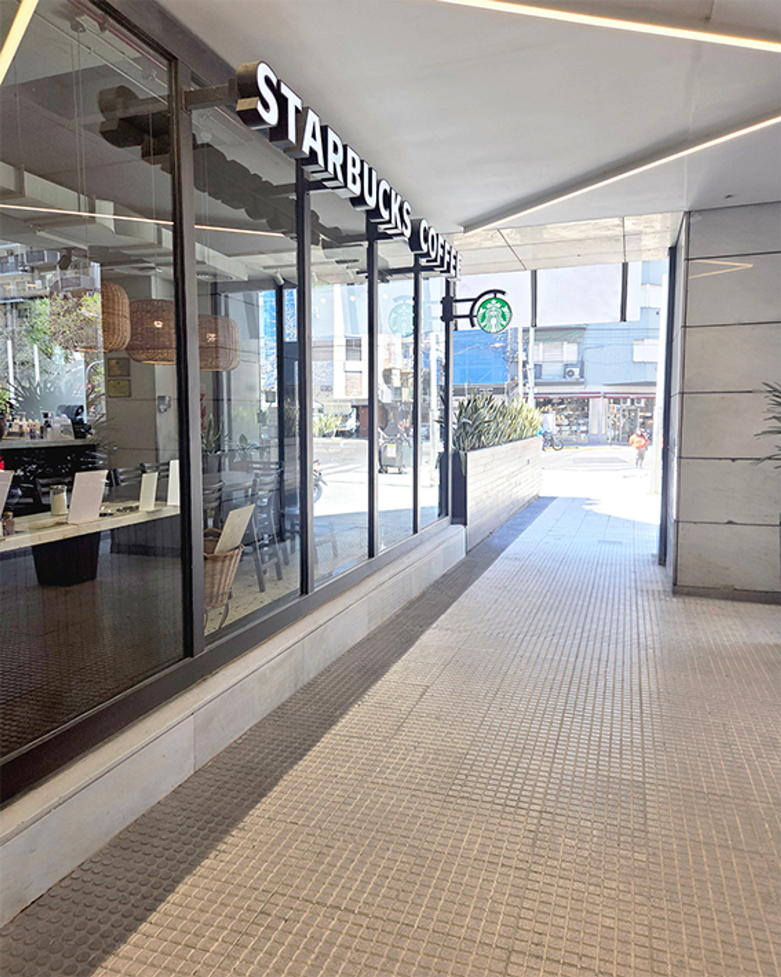 Graníticos DUBRA en vereda exterior: el 64 panes blanco espuma, pensado para alto tránsito.
