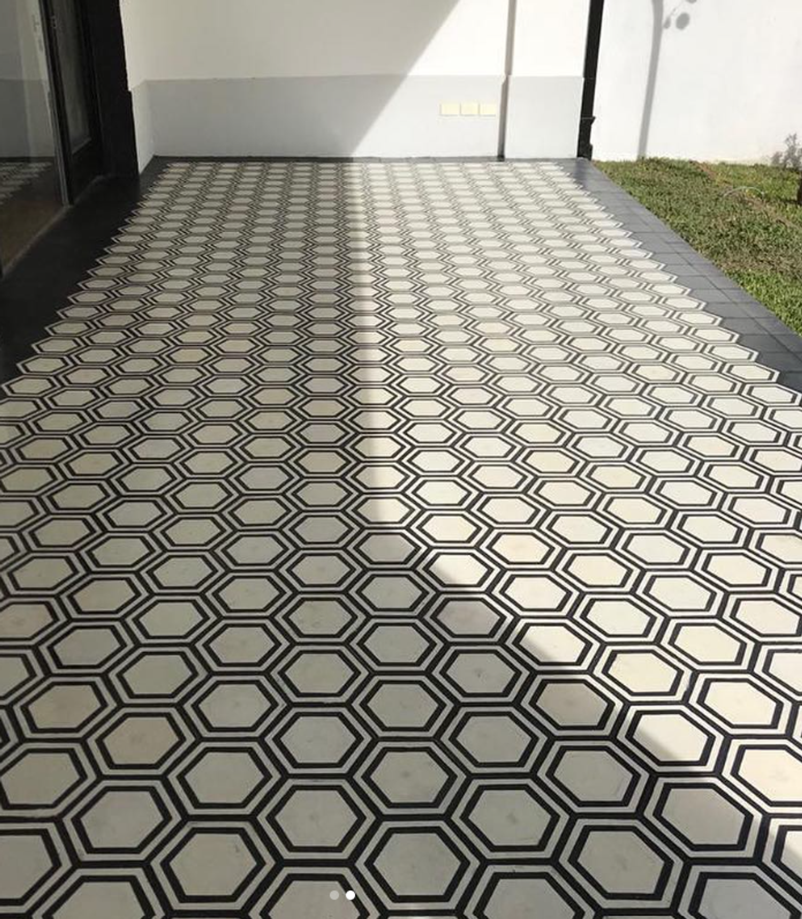 Piso exterior con diseño geométrico tipo calcáreo 20x20 colocado en una galería o patio residencial, una opción decorativa para espacios al aire libre.