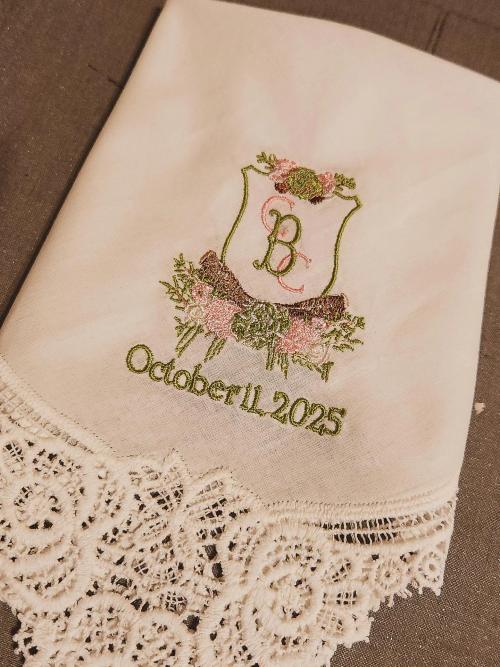 Cream lace-trimmed wedding handkerchief embroidered with a floral crest, monogram "BC", and the date "October 11 2025"