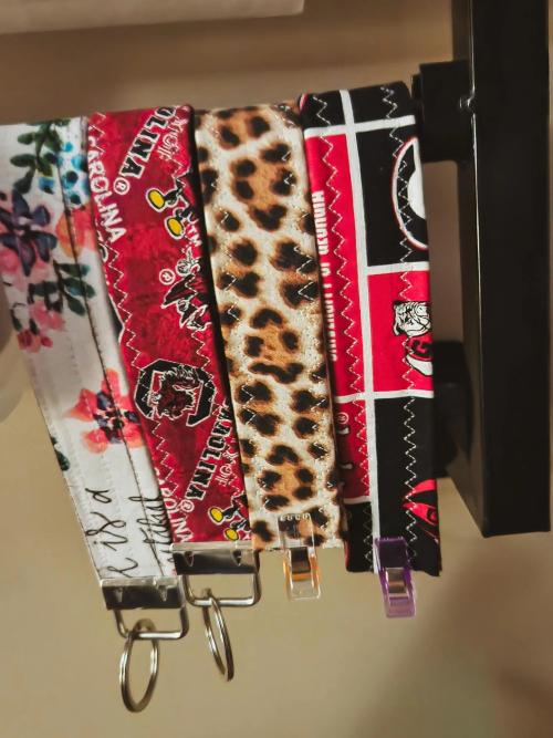 Four fabric wristlet key fobs in floral, University of South Carolina Gamecocks, leopard print, and University of Georgia Bulldogs patterns