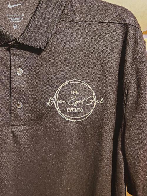 "The Brown Eyed Girl Events" circular business logo embroidered on the chest of a heather brown polo shirt