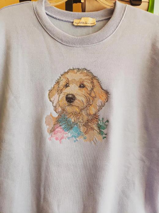 Lavender pullover sweatshirt with a detailed photo-realistic embroidered portrait of a golden doodle puppy and a watercolor-style paint splash accent