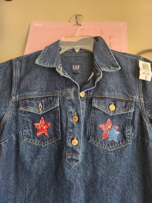 Denim button-up jacket with bandana-print fabric star appliques stitched onto both chest pockets.