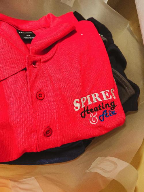 "SPIRES Heating & Air" business logo embroidered on the chest of a folded red polo shirt