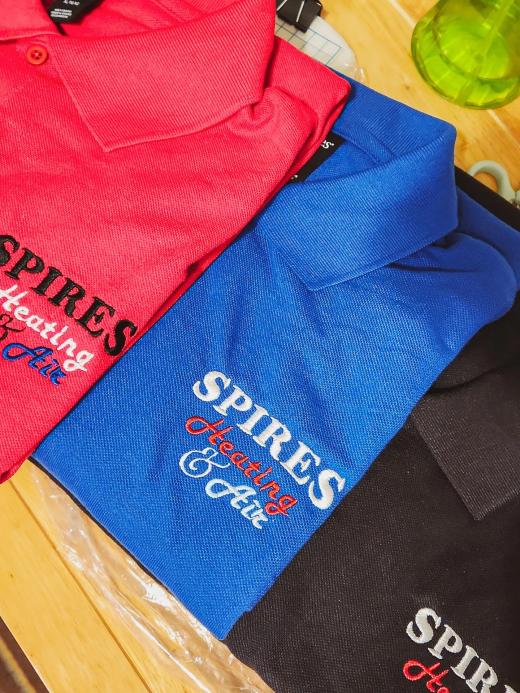 "SPIRES Heating & Air" business logo embroidered on the chest of folded red, blue, and black polo shirts