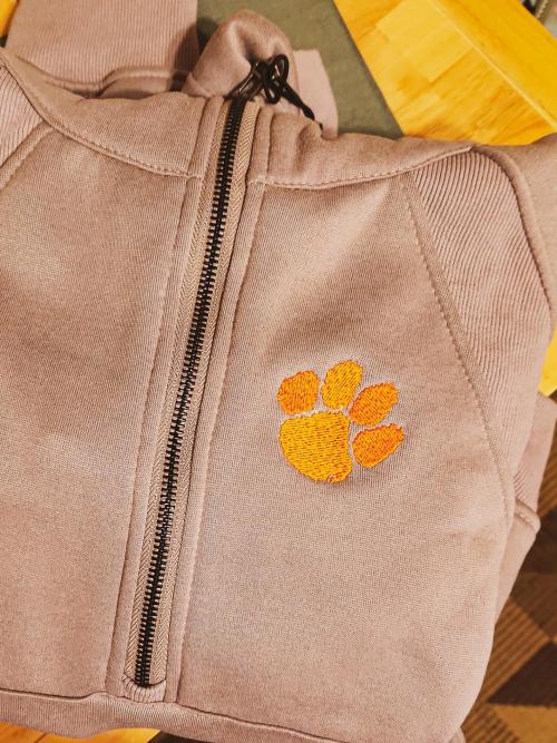Tan full-zip jacket with an orange Clemson-style tiger paw print embroidered on the chest