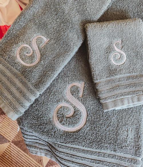 Brown block-letter name "DOC" embroidered on a beige knit baby beanie