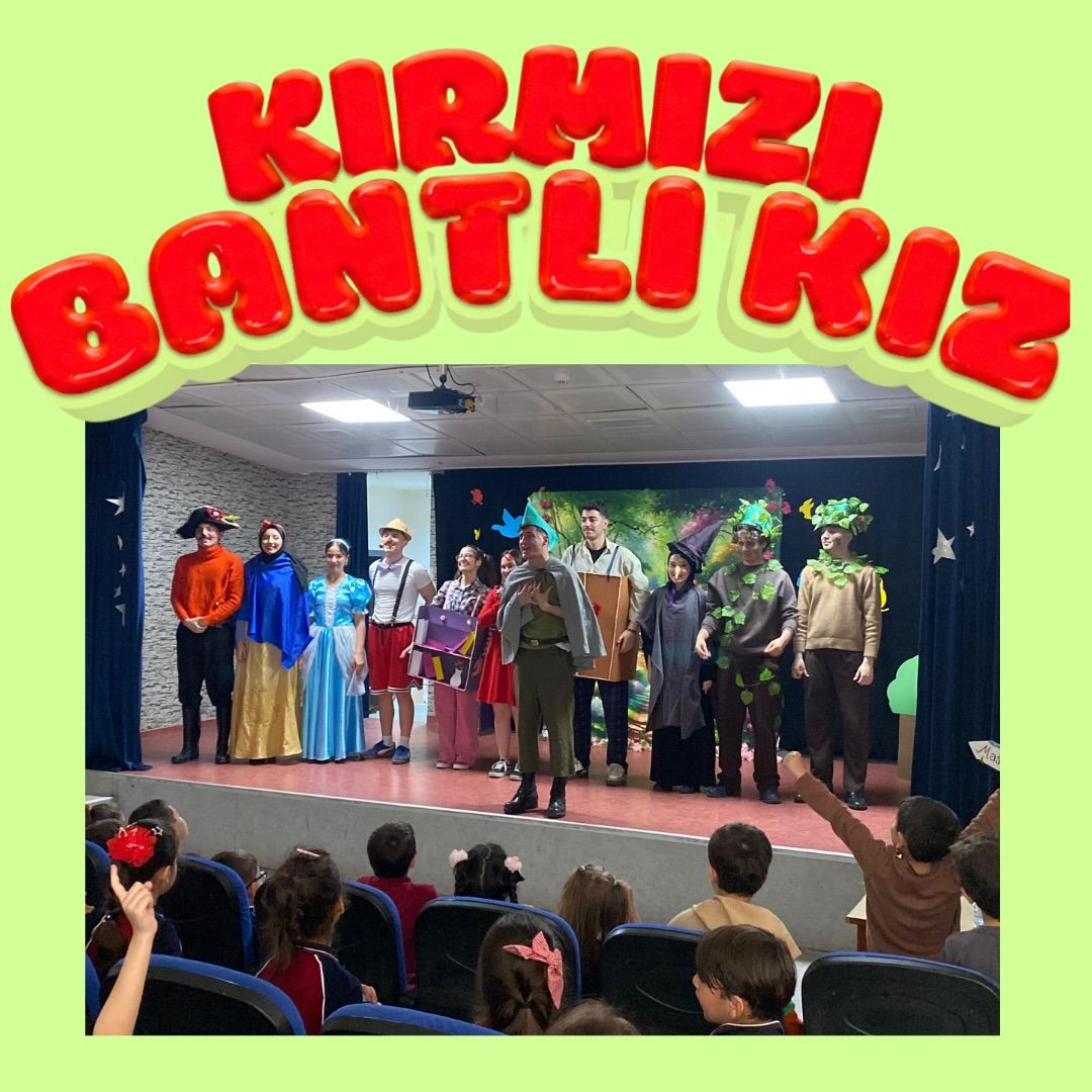 Kırmızı Bantlı Kız gösterisinde renkli kostümlü oyuncular sahnede selam verirken izleyiciler önde görülüyor.