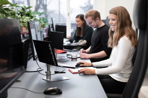 Three happy colleagues at a shared workplace