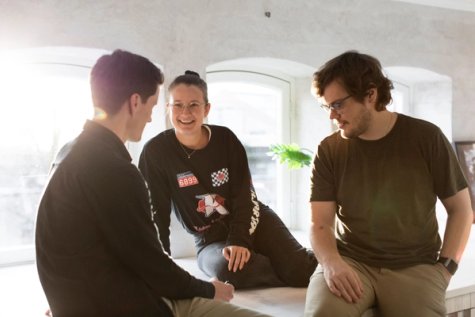 Three smiling colleagues talking
