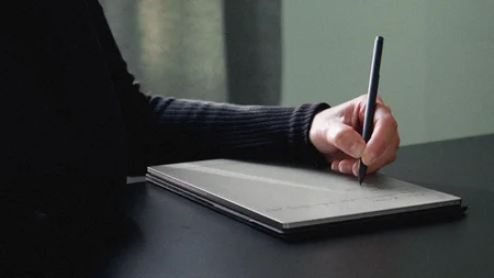 Emily Stathaki sits at her desk, writing on her reMarkable Paper Pro using her Marker