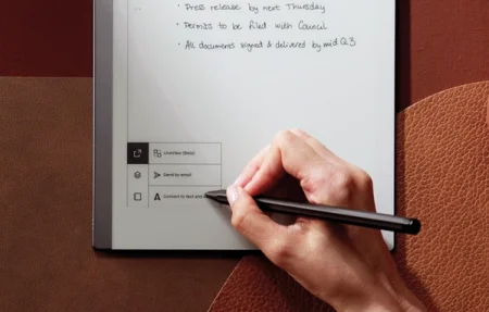 A reMarkable paper tablet showing a hand tapping the handwriting conversion tool.