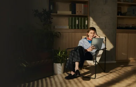 Woman seated with reMarkable Paper Pro tablet. Reading a document on the device in natural light.