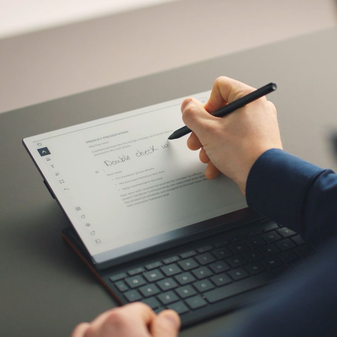 reMarkable paper tablet: a person writing a note with the Marker Plus on the device with Type Folio.