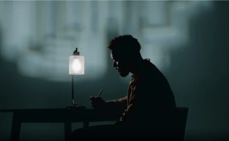 Person working at a desk in the evening with a Marker in hand.