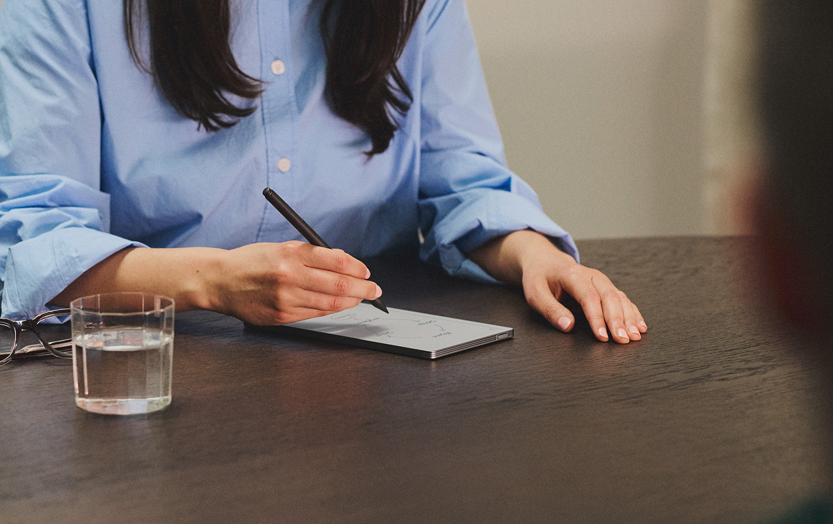 A reMarkable paper tablet with a person writing a note with the Marker.
