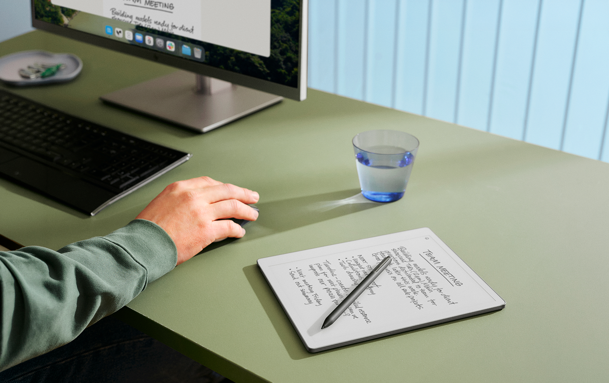 A person working on their desktop while using reMarkable Paper Pure tablet on the desk.