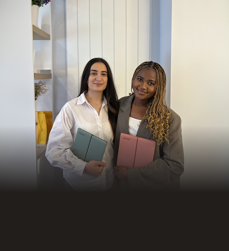 Dr. Lydie Kitenge holding a reMarkable Paper Pure tablet in a Mist Green sleeve folio, and Dr. Hazal Trench holding one in a Desert Pink sleeve folio.