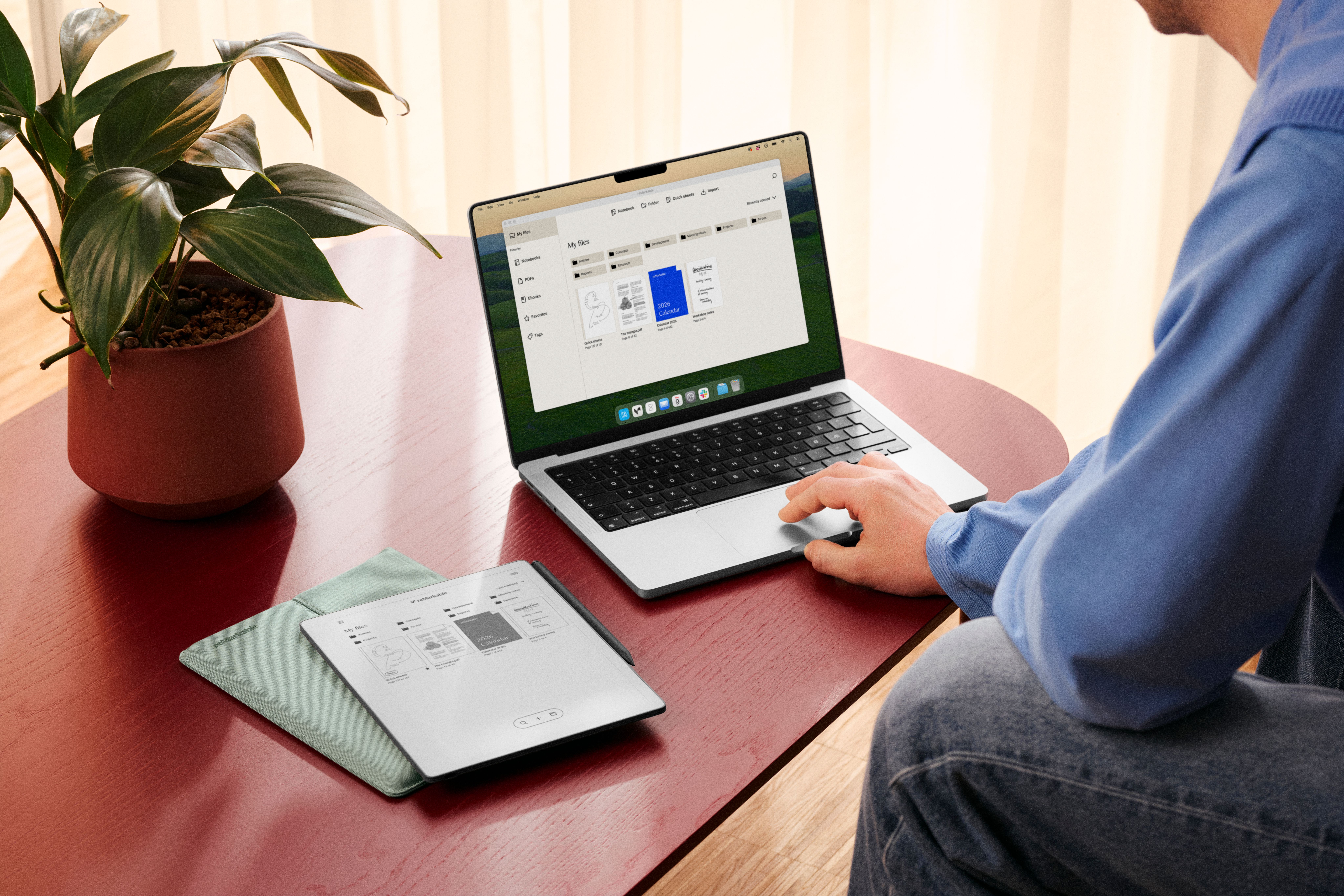 A man sitting at a table, importing files to his reMarkable Paper Pure from a desktop
