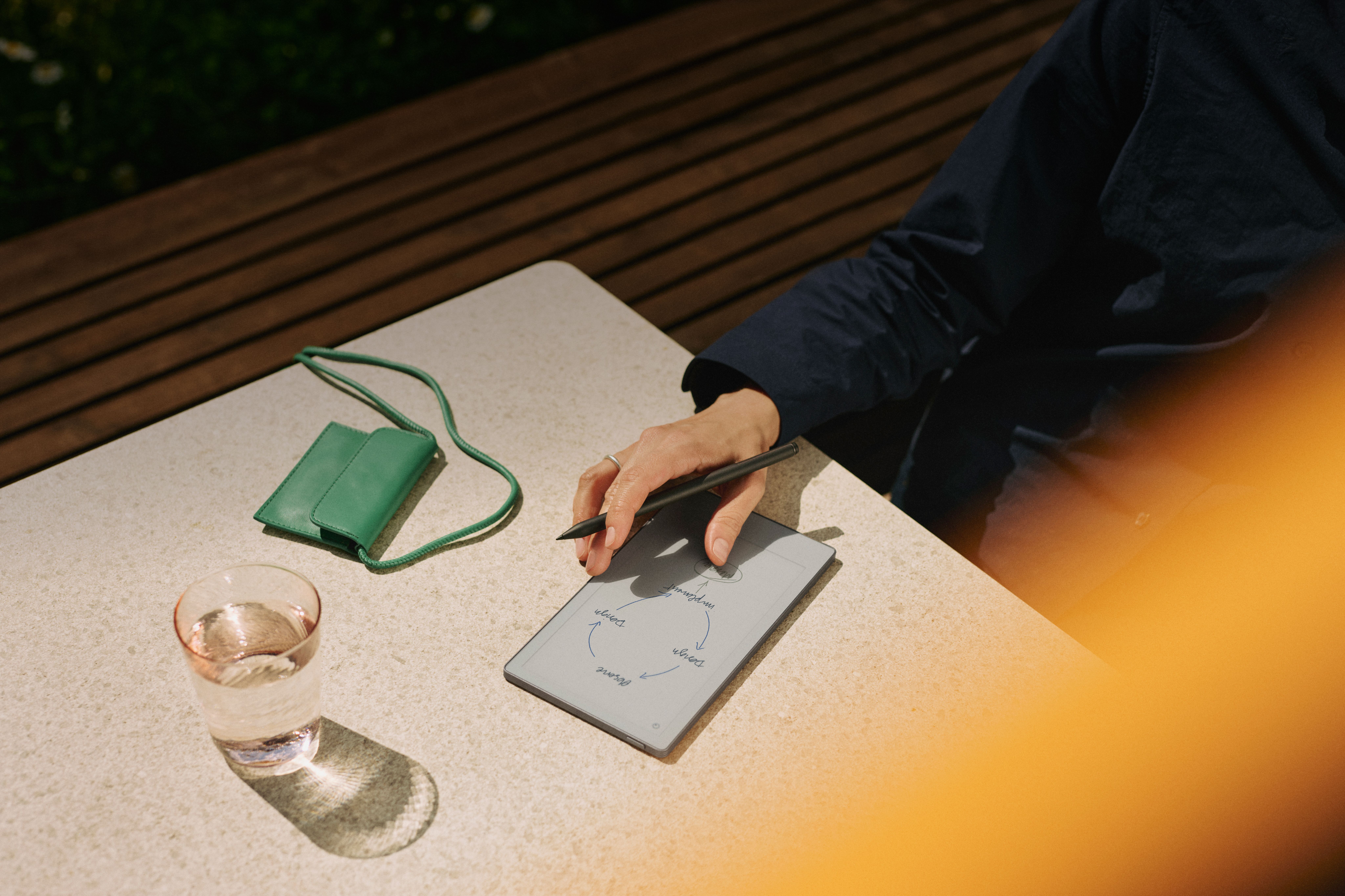 reMarkable Paper Pro Move being used outside on a table in the sun.