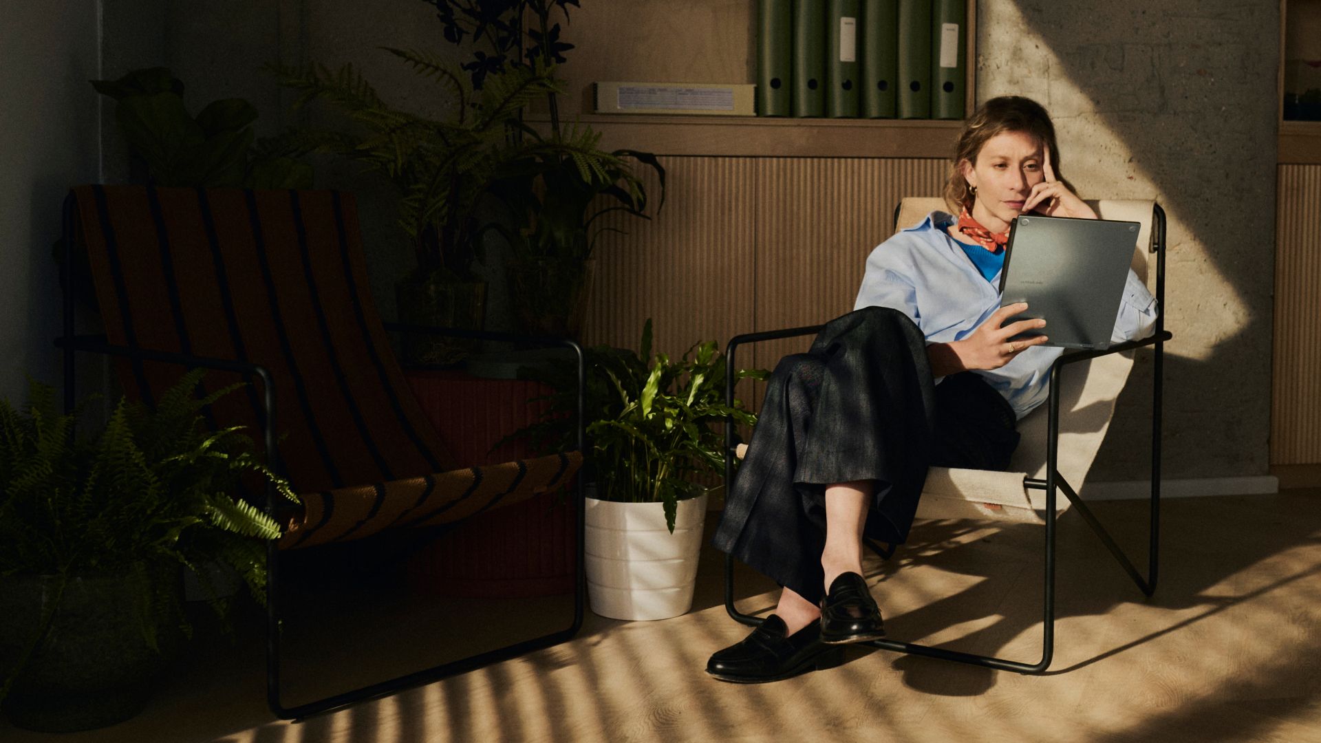 Woman in chair holding reMarkable Paper Pro