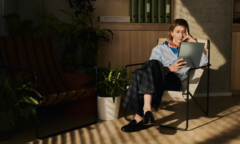 Woman in chair holding reMarkable Paper Pro