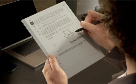 Person signing a document on a reMarkable paper tablet with the Marker.