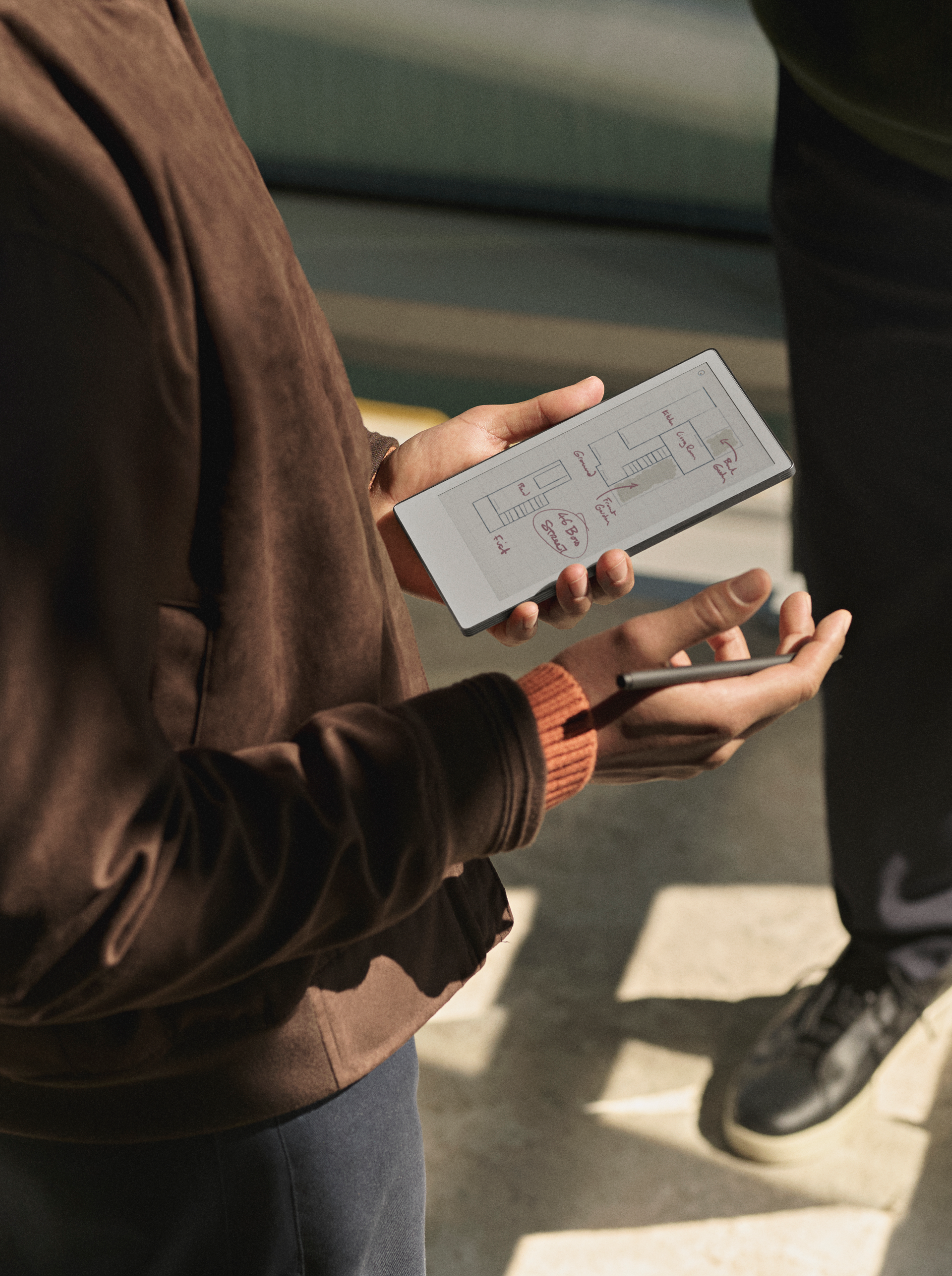 A man standing up holding reMarkable Paper Pro Move
