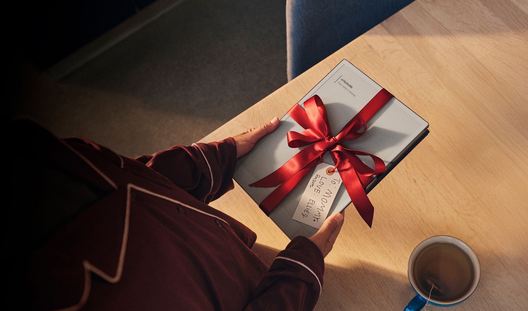 A reMarkable paper tablet wrapped as a gift with a red ribbon.