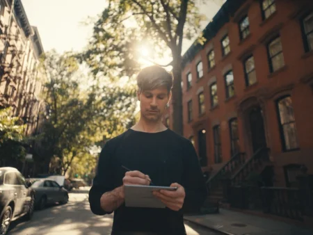 Matthew writing on his reMarkable paper tablet with the Marker in an urban neighborhood.