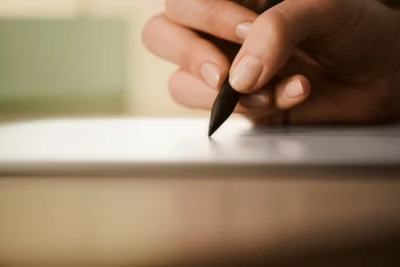 A hand writing with the Marker on the reMarkable paper tablet.